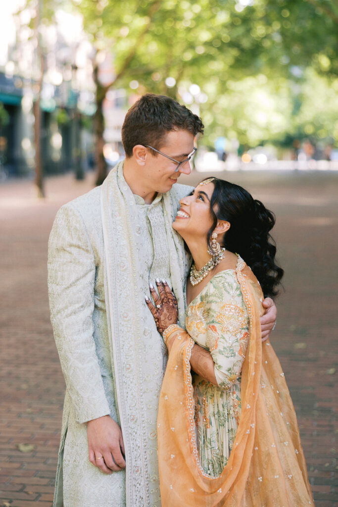 Bride and groom hug during the sangeet before their wedding day in Pioneer Square in Seattle