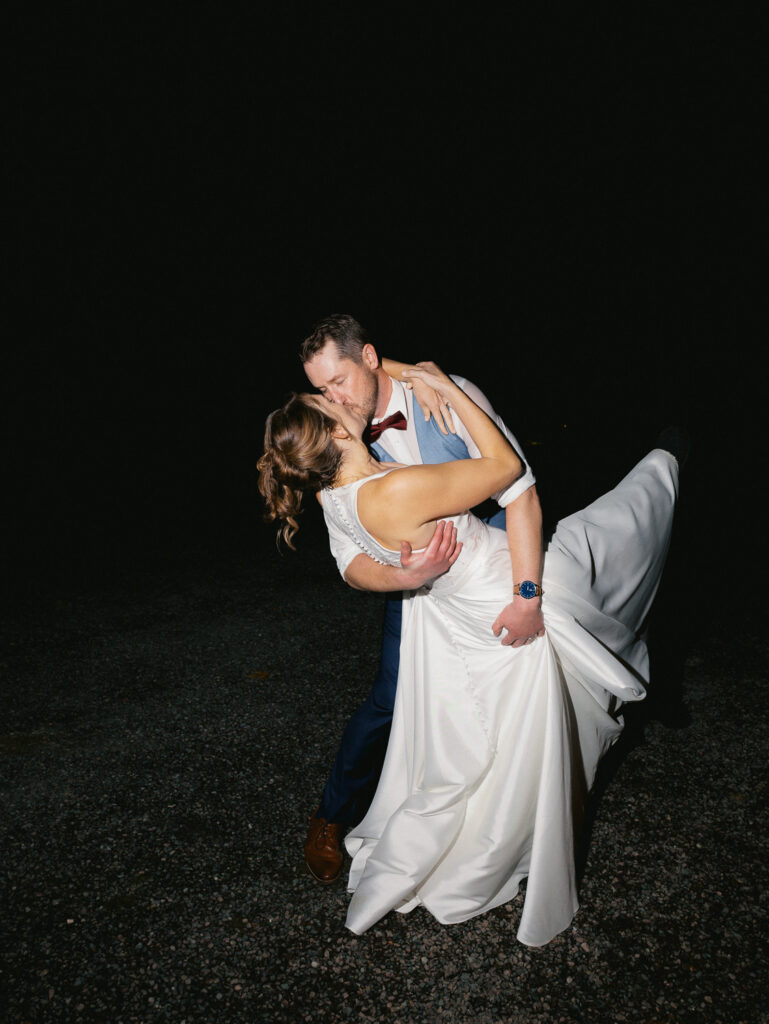 Bride and groom embrace for a loving kiss after their wedding day