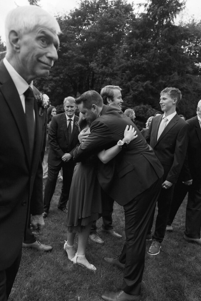 Groom hugs family members after wedding ceremony